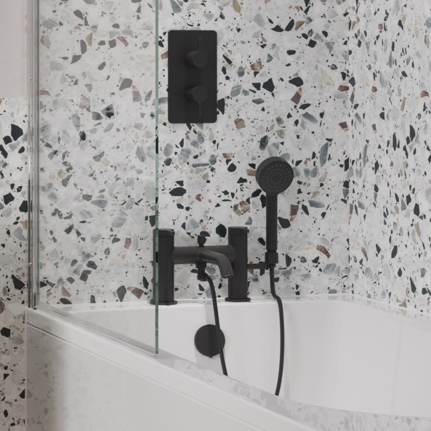 Product lifestyle image of Britton Hoxton 2,0 Matt Black Bath Shower Mixer fitted to bath end next to Terrazzo walls HOX422DM